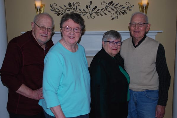 Four residents smiling together in a common area