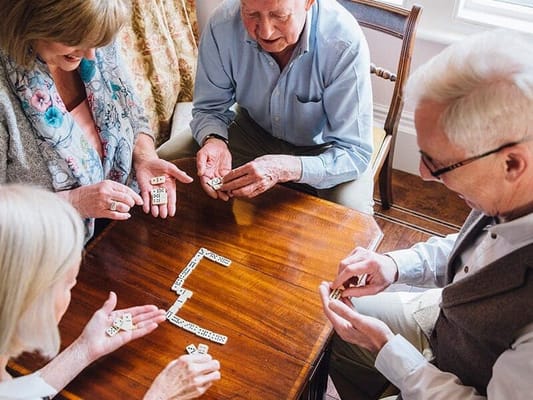 Residents playing dominoes at a table