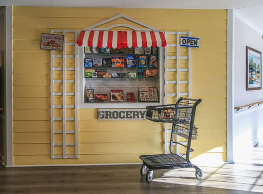 Interior view of a grocery area with a sign and shopping cart