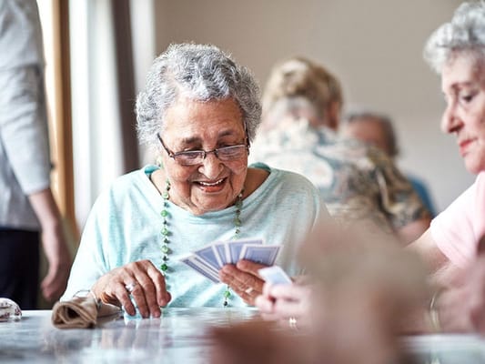 Residents enjoying a card game in an activity room