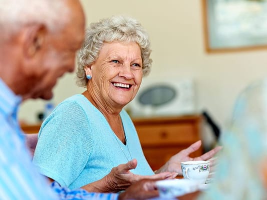 Smiling resident enjoying tea in a common area