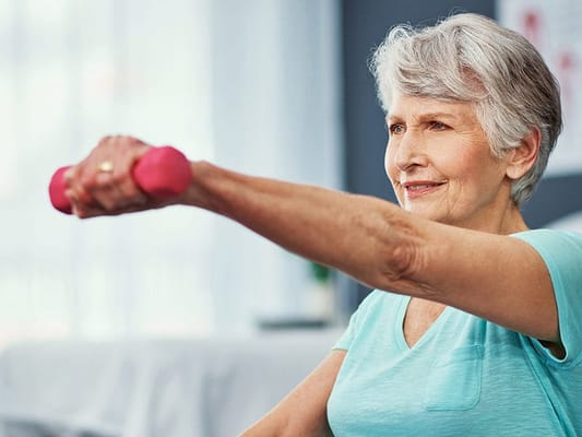 Senior woman participating in exercise with weights