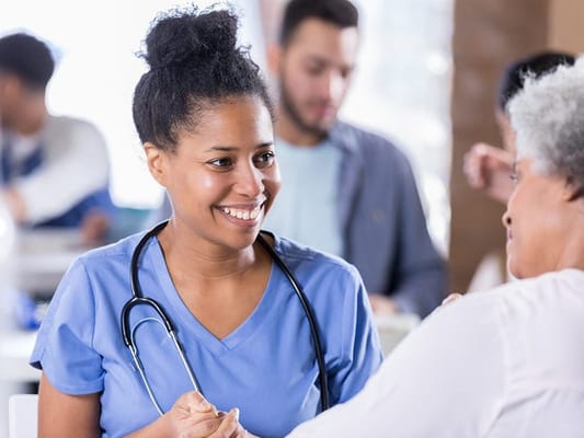Nurse interacting with a senior resident in a common area