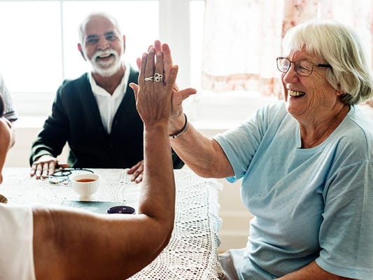 Residents enjoying a lively game at a table