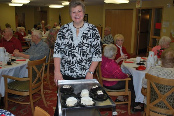 Staff member serving dessert in dining area
