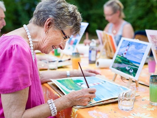 Residents participating in an outdoor painting activity