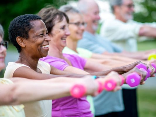 Residents exercising outdoors with weights