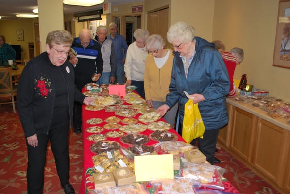 Residents enjoying a bake sale with various treats on display