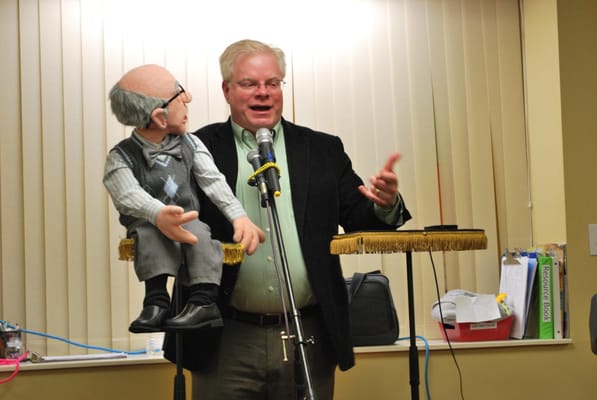 Entertainer performing with a puppeteer at an event