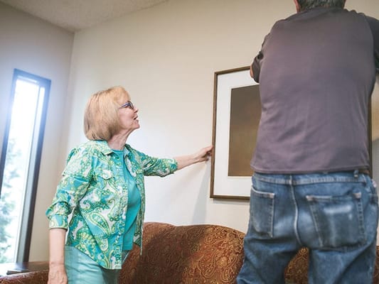 Residents hanging artwork in a common area