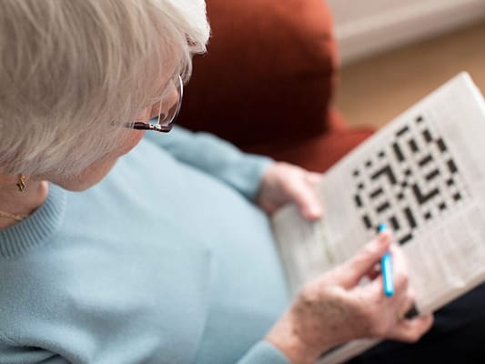 Senior woman engaging in a puzzle activity indoors