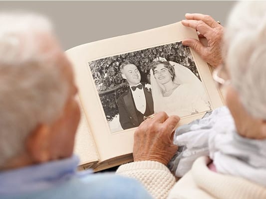 Elderly couple looking at a wedding photo album