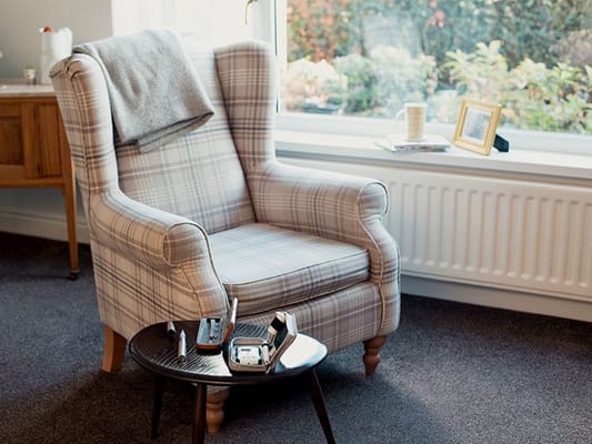 Cozy armchair beside a sunny window in a common area
