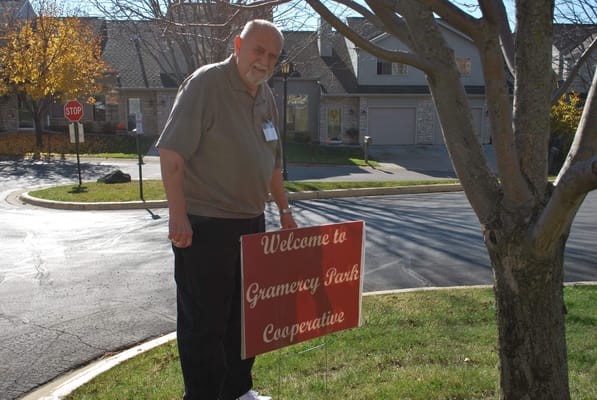 Resident holding a welcome sign outside the facility