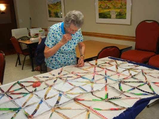 Resident engaged in a quilting activity in a common area