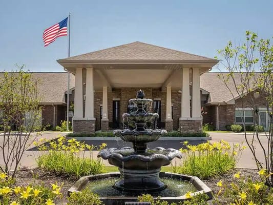 Exterior view of the facility with fountain and flag