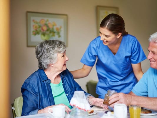 Staff member interacting with residents during meal time
