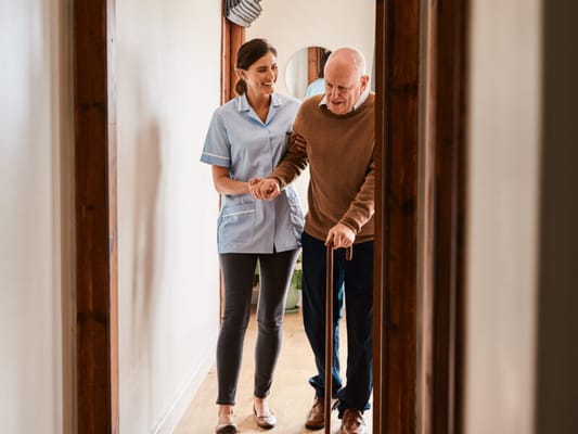 Staff assisting a resident in a hallway