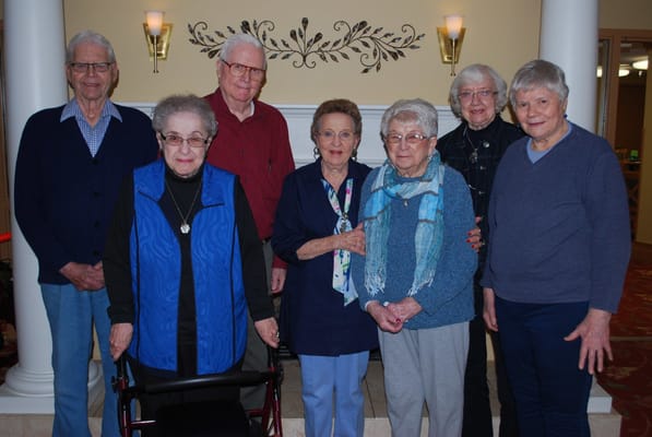 Residents and staff smiling together in a common area