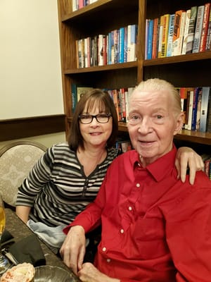 Resident and caregiver in a cozy library setting