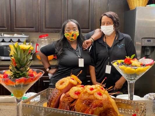 Staff members preparing a meal with a fruit display