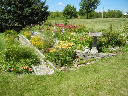 A vibrant garden with colorful flowers and a birdbath