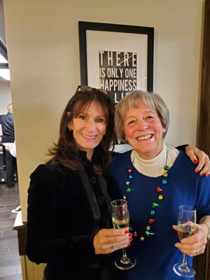 Two women celebrating with champagne in a common area