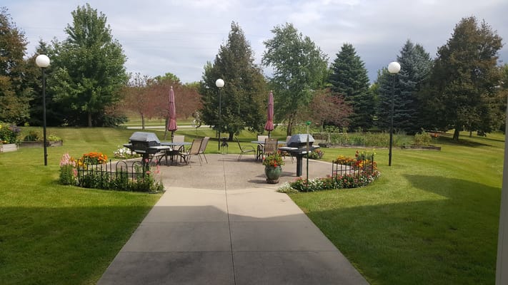 Outdoor seating area with grills and flower beds