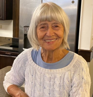 Happy resident smiling in a bright kitchen area