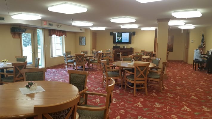 Common area with tables and chairs set up for residents