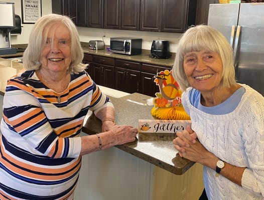 Two residents smiling in a cozy kitchen area