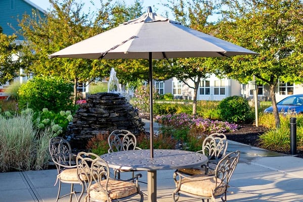 Outdoor seating area with a fountain and flower gardens