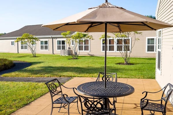 Outdoor seating area with patio umbrella and landscaping