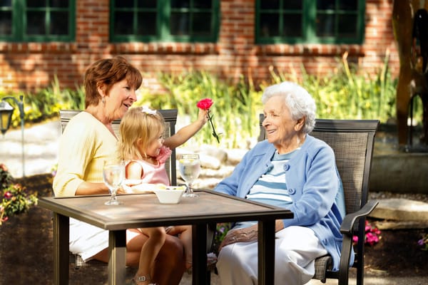 A woman and a young girl with a resident outdoors.