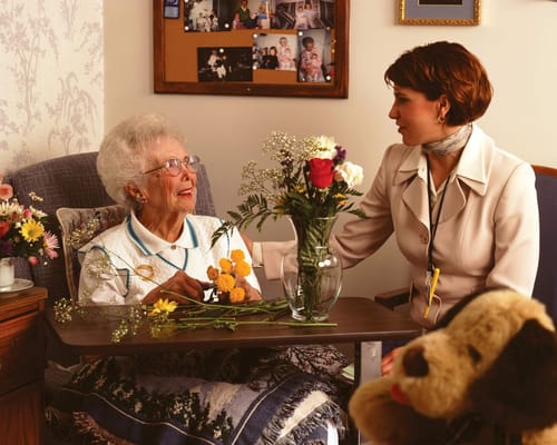 A staff member interacting with a smiling resident