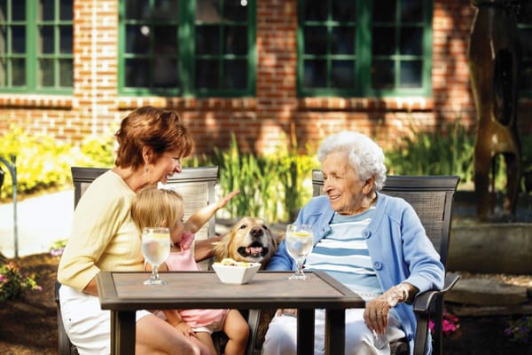 Residents enjoying time outside with family and a dog