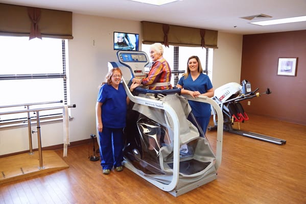 Residents engaging in physical therapy with staff assistance