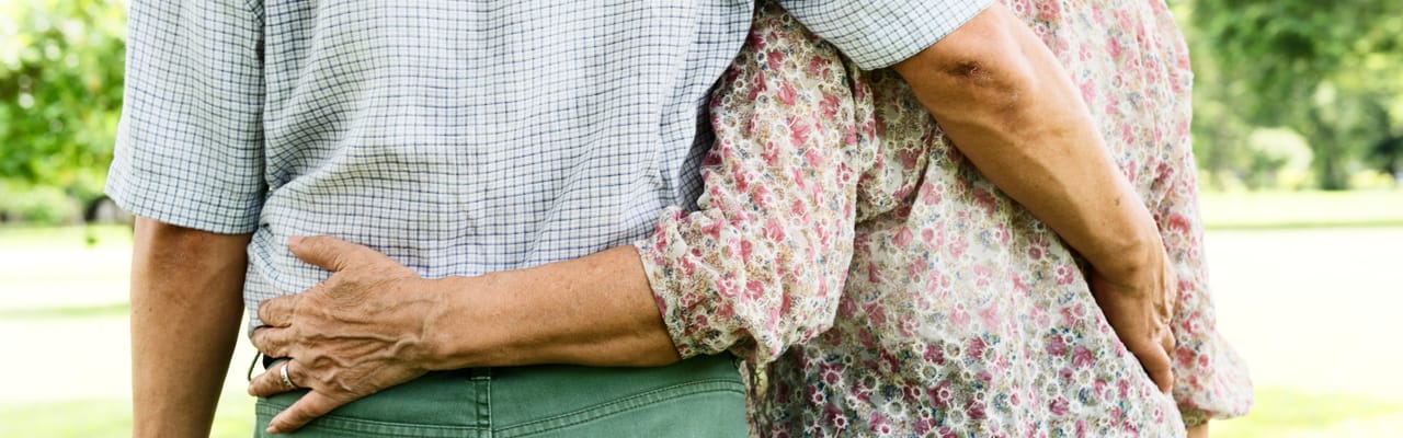 Two residents embracing in a park setting