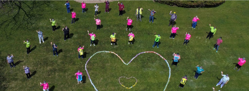 Residents participating in an outdoor activity forming a heart shape