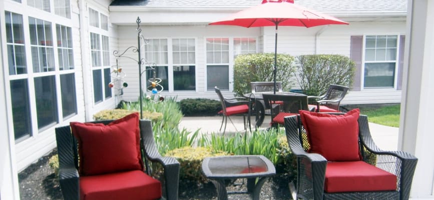 Outdoor seating area with red cushions and umbrella