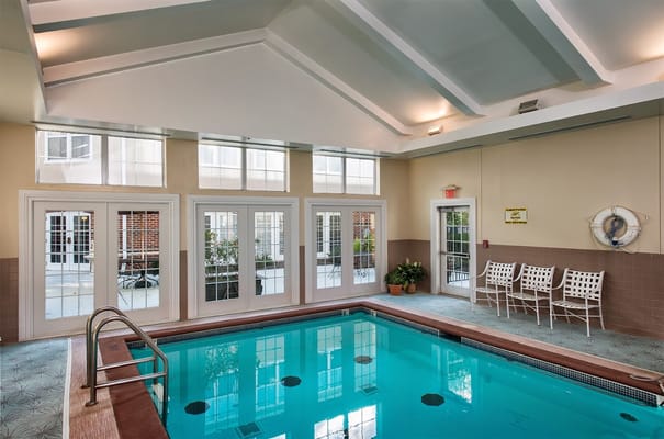 Indoor pool with seating area and large windows