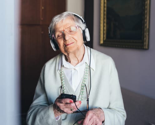 Senior woman enjoying music with headphones