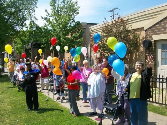 Residents celebrating outdoors with colorful balloons