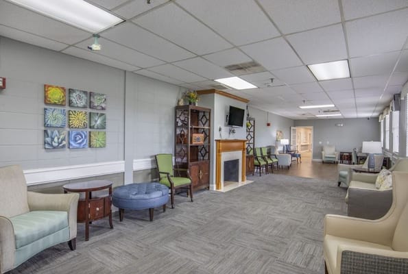 A spacious living room with comfortable seating and decorative wall art.