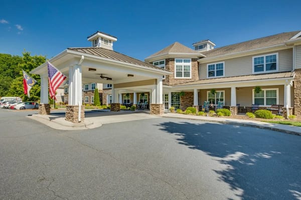 Main entrance with flags and parking area at Arbor Ridge at Stanleyville
