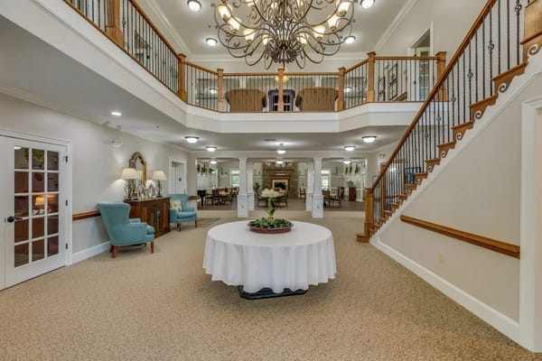 Spacious lobby with chandelier, seating area, and dining space
