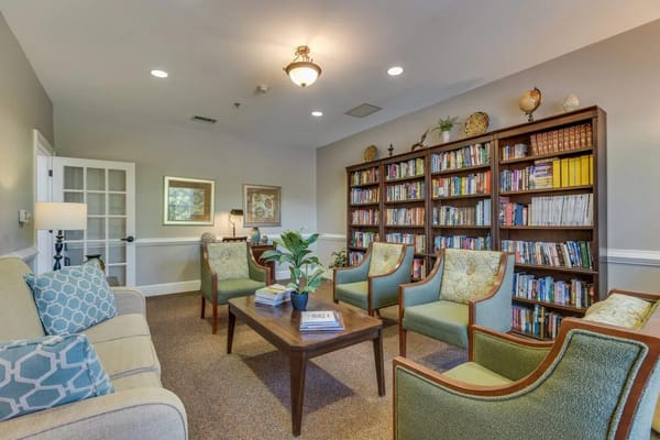 Comfortable lounge with bookshelves and seating at Arbor Ridge