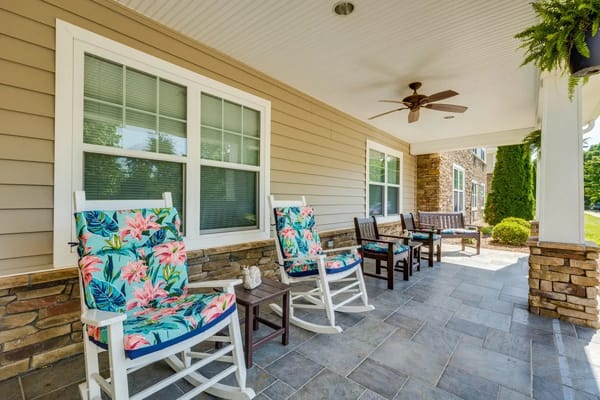 Outdoor seating area with floral-patterned rocking chairs and stone accents