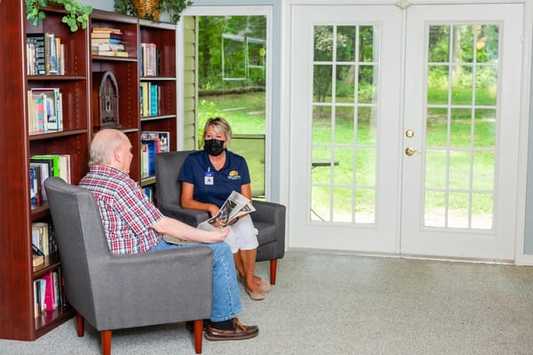 Resident and staff member chatting in a cozy lounge