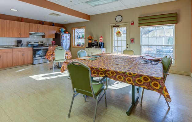 Bright common area with kitchen amenities and dining tables